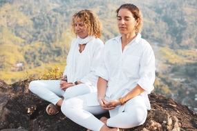 两个美女山顶静心盘腿打坐摄影图片